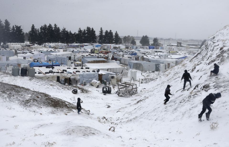 Syrian refugees go out in the snow during a winter storm on December 11 in the Lebanese town of Zahle.
