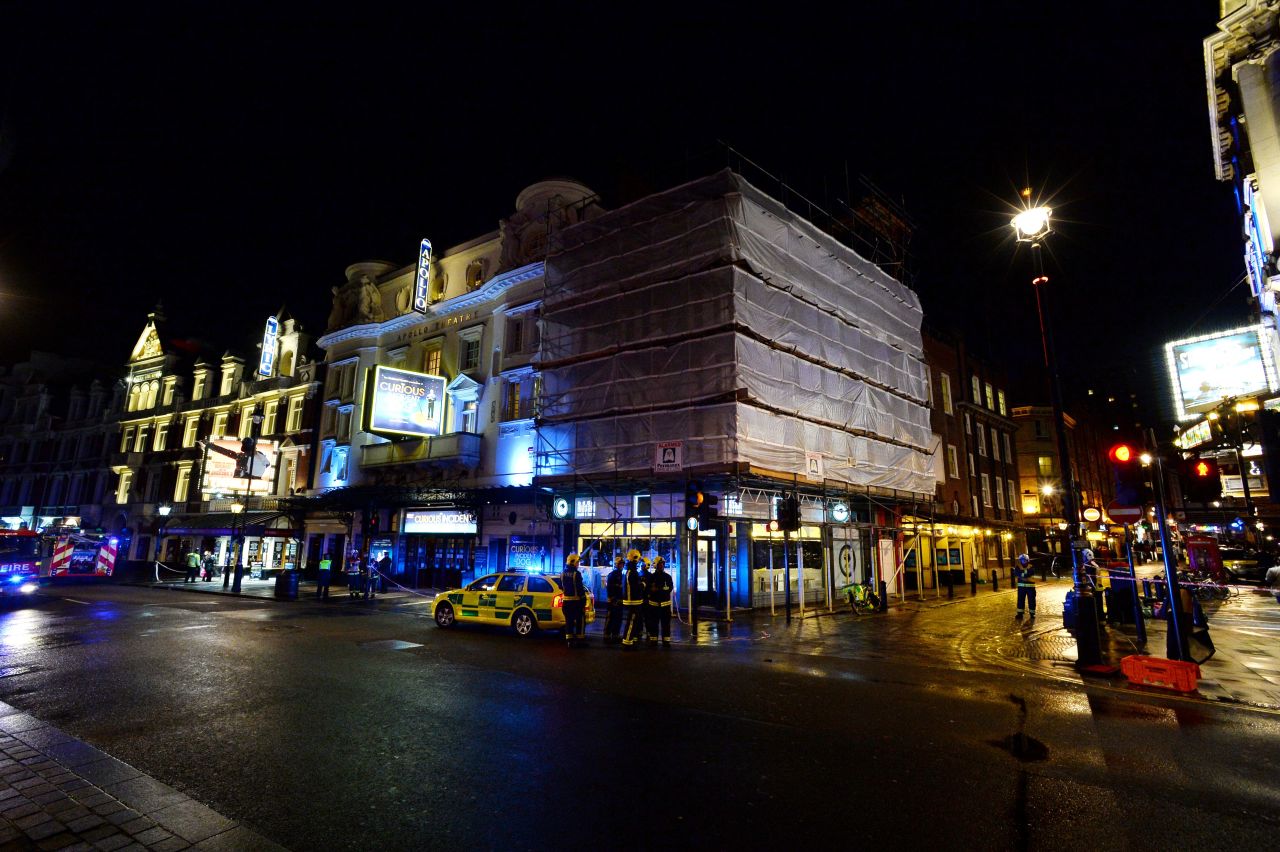 Emergency service personnel work outside London's Apollo Theatre on Thursday, December 19. Part of the theater's ceiling collapsed during a performance Thursday night, injuring dozens of people, officials said.