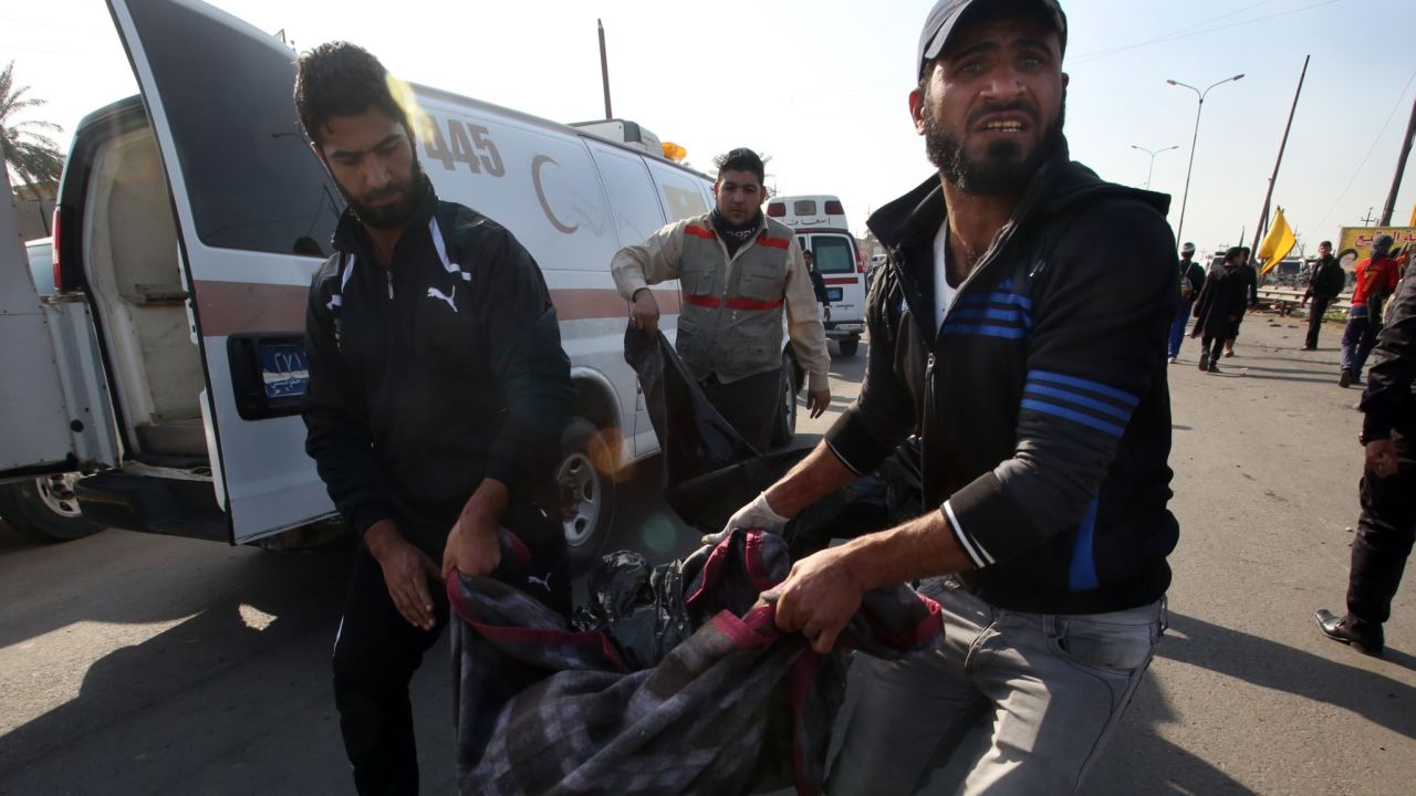 Iraqi men carry a victim of a suicide attack in the Dura area of south Baghdad on December 19.