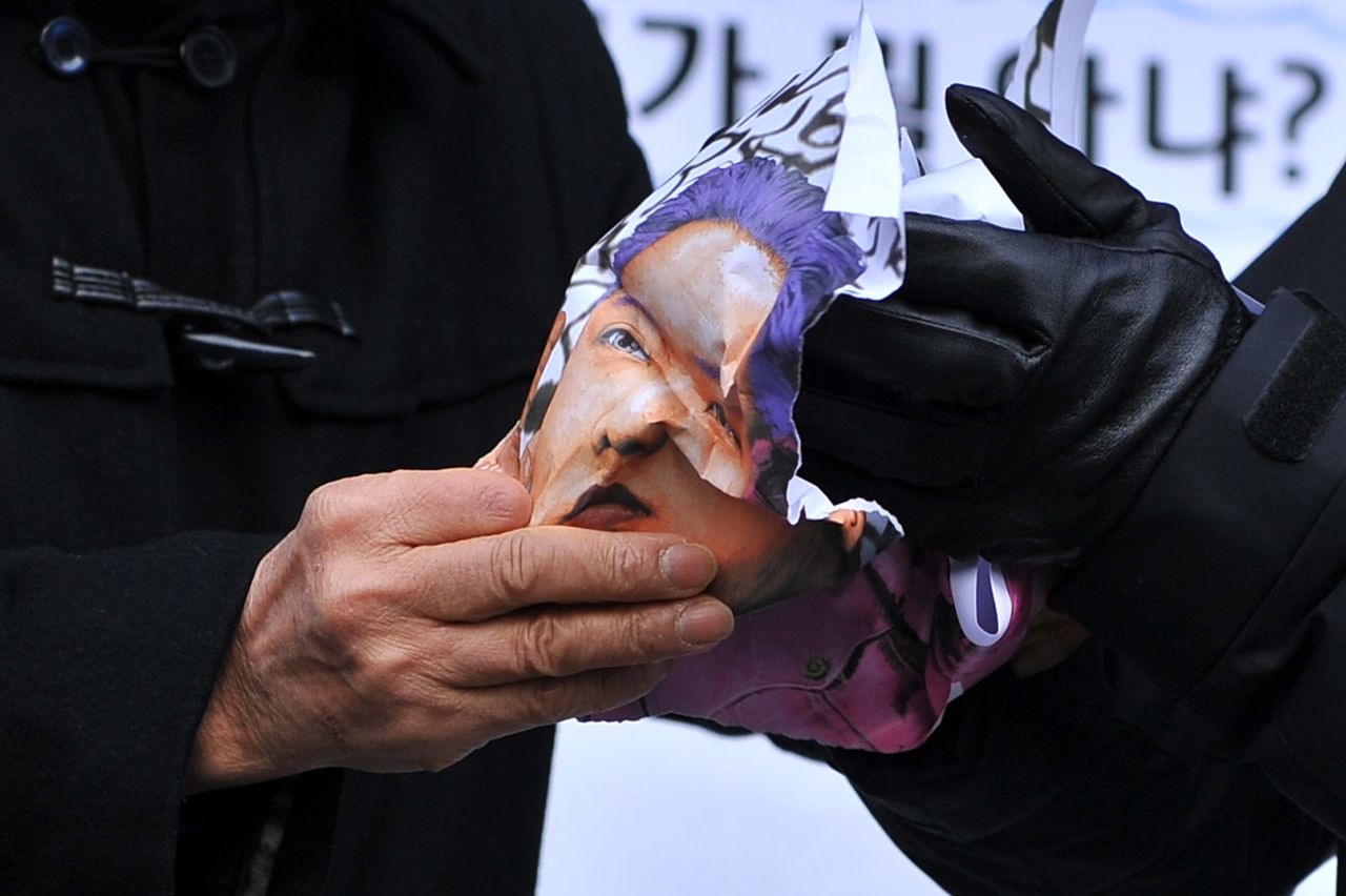 North Korean defectors crumple a caricature of Kim during a protest in Seoul on December 17.