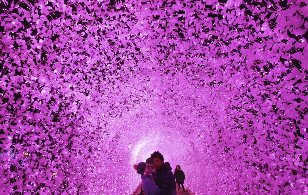 DECEMBER 20 - GAPYEONG, SOUTH KOREA: A couple pose under an illuminated tunnel to celebrate the coming Christmas and New Year at the Garden of Morning Calm. Christmas is one of the biggest holidays in South Korea.