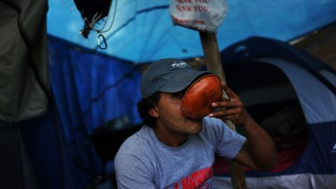 A homeless person takes a drink outside of the tent encampment where he lives in Waterbury, Connecticut.