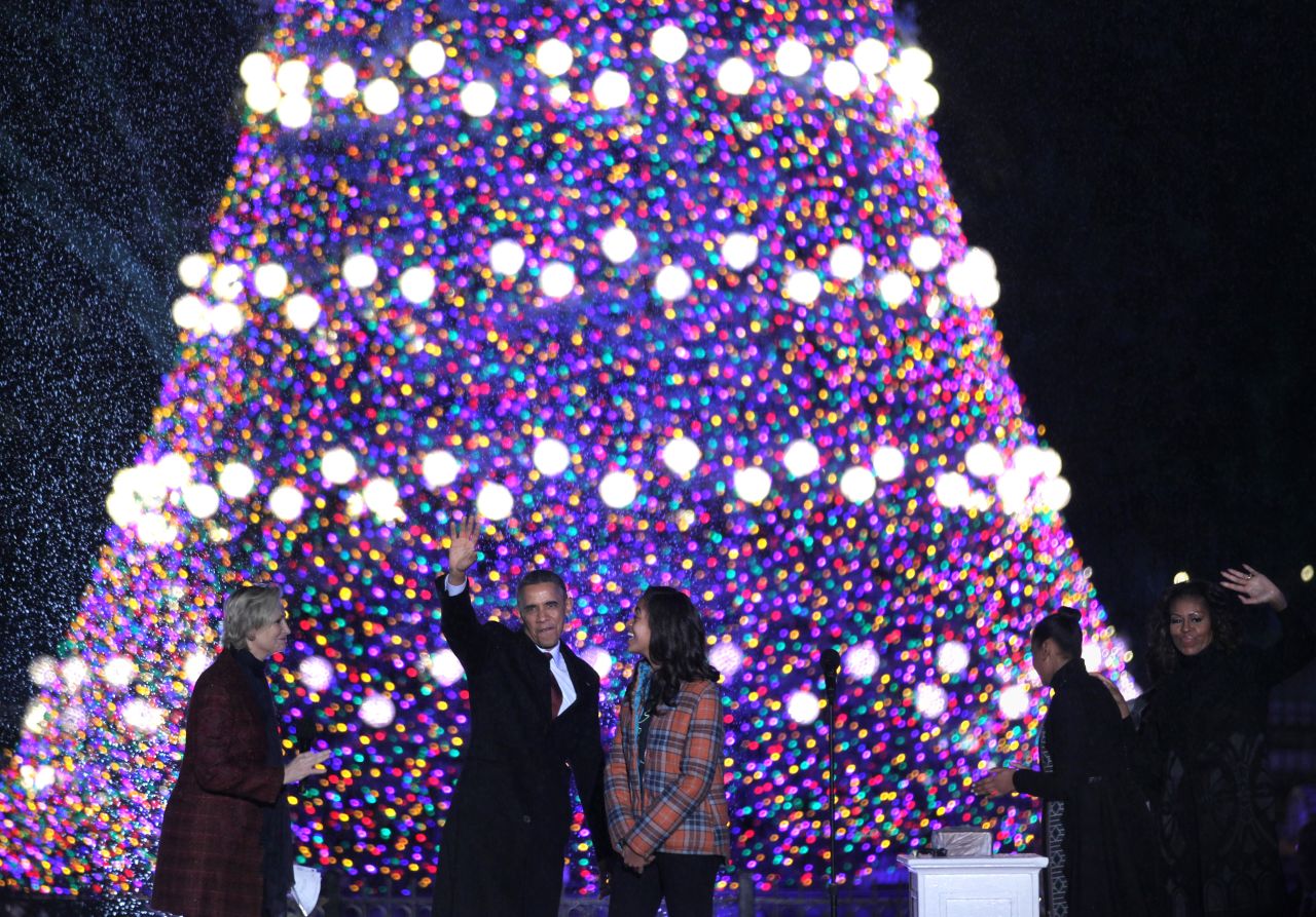 President Barack Obama and first lady Michelle Obama, and daughters Sasha and Malia, participate in the lighting ceremony of the National Christmas Tree as actress and host Jane Lynch, left, looks on during a ceremony at the Ellipse on Friday, December 6.