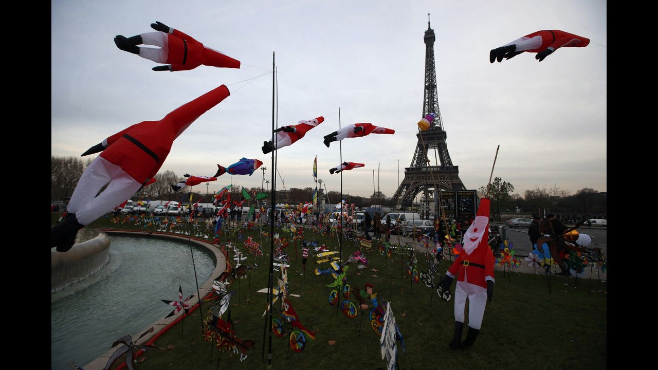 Kites in the shape of Santa Claus glide in the wind as part of an exhibition next to the Eiffel Tower in Paris on Tuesday, December 17.