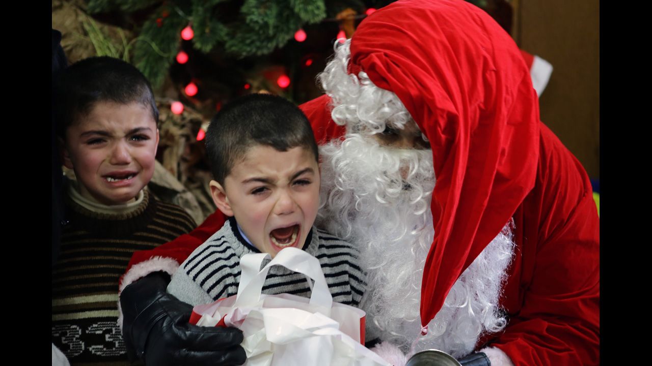 Boys cry as they are pictured with Santa Claus at a kindergarten in Damascus, Syria, on December 19.