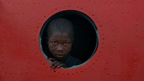 A boy looks out the broken window of a plane being used as shelter at M'Poko International Airport on December 21.