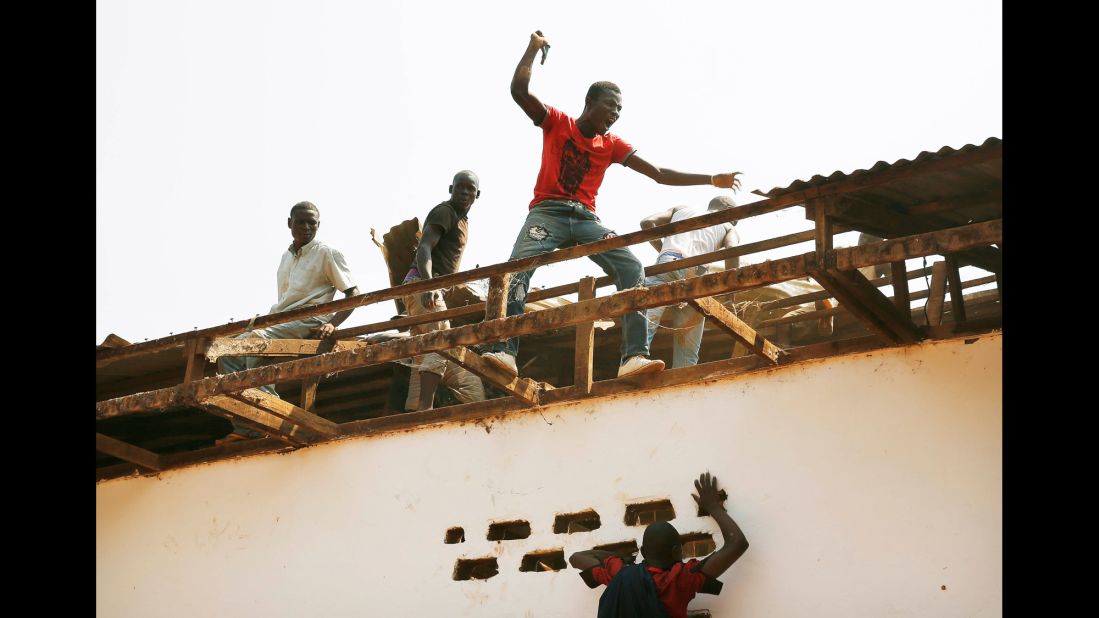 Christian men tear off pieces of the Gobango Mosque in Bangui on December 20.