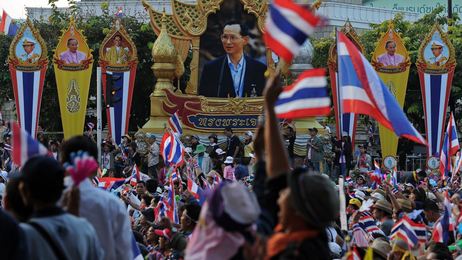 Thai anti-government protesters wave national flags as they rally in Bangkok on December 22.