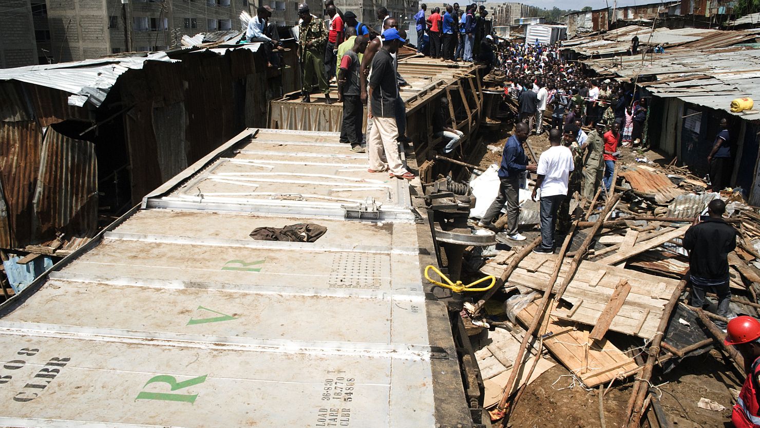 People stand on a cargo train after it derailed in the sprawling Nairobi slum of Kibera.