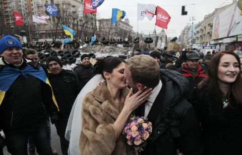 Newlyweds Mikhail and Margarita Nakonechniy kiss in front of barricades on Independence Square in a gesture of support for pro-Europe activists in Kiev, Ukraine, on Saturday, December 21. Protesters have poured into the streets of the Ukrainian capital, angered by their government's move away from the European Union in favor of closer ties with Russia.