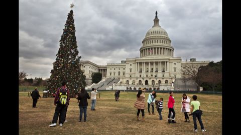 Tourists visit the U.S. Capitol Christmas tree in Washington on December 22 under cloudy skies with temperatures in the low 70s.