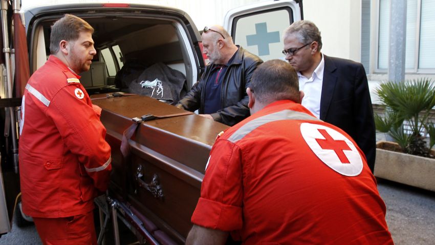 Members of the Lebanese Red Cross carry the coffin of Abbas Khan, a British doctor who died in a Syrian jail, as it arrives in Beirut on December 21, 2013.