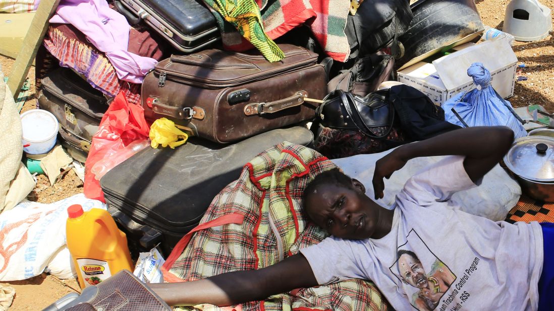 A mother displaced by recent fighting in South Sudan rests on top of her belongings in a makeshift U.N. shelter on Monday, December 23.