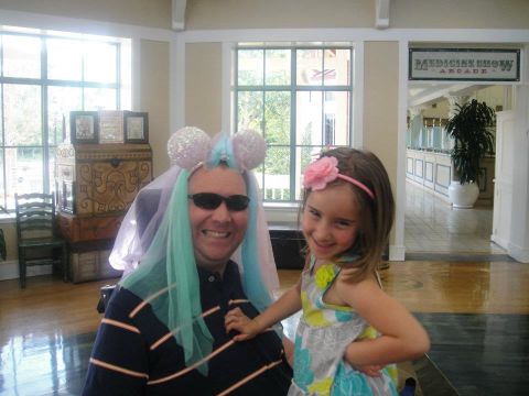 Izzy and her dad  smile for the camera at Disney World. "She bought those ears and while we were waiting for the bus at Disney, she put them on him and asked him to pose with her," Hayes said. "She thinks it's hysterical to make him look silly so she does it at much as possible."