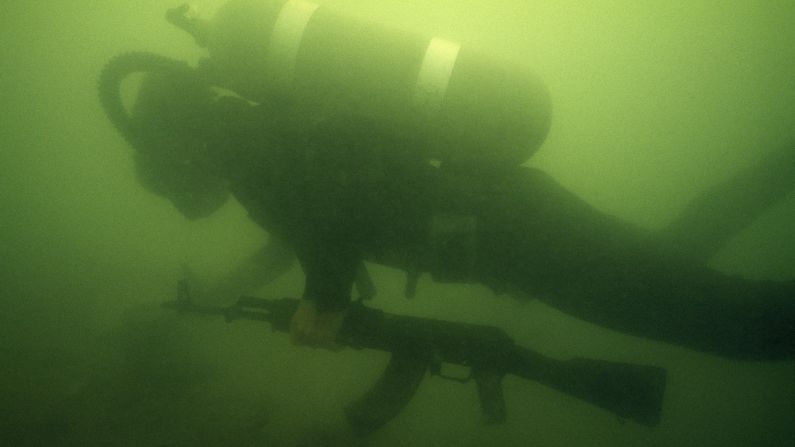 A diver retrieves an AK-47 from the bottom of the Suez Canal in Egypt in 1975.