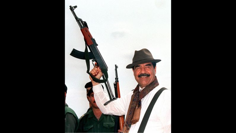 Then-Iraqi President Saddam Hussein brandishes an AK-47 during his visit to villages in northern Iraq in 1998, in this Iraqi News Agency released photograph.