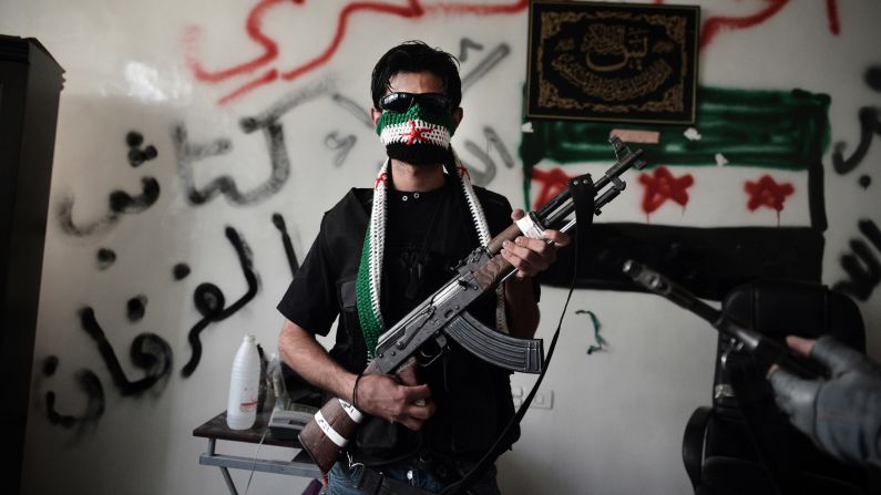 A Syrian opposition fighter poses with his AK-47 in Aleppo, Syria, in 2012.