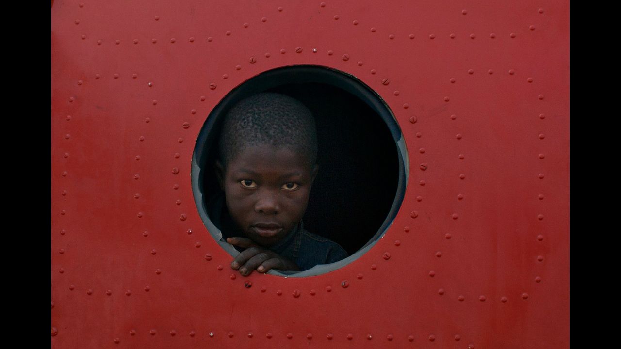 <strong>December 21: </strong>A boy looks out the broken window of a plane that serves as shelter in a makeshift camp housing more than 40,000 people at M'poko Airport in Bangui, Central African Republic. They've displaced by recent violence in the country.