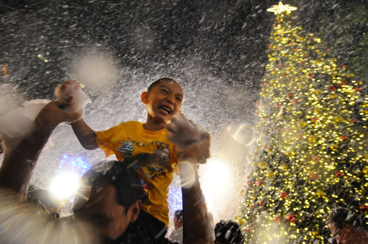 A child enjoys artificial snow at a shopping mall in Singapore on Tuesday, December 24.