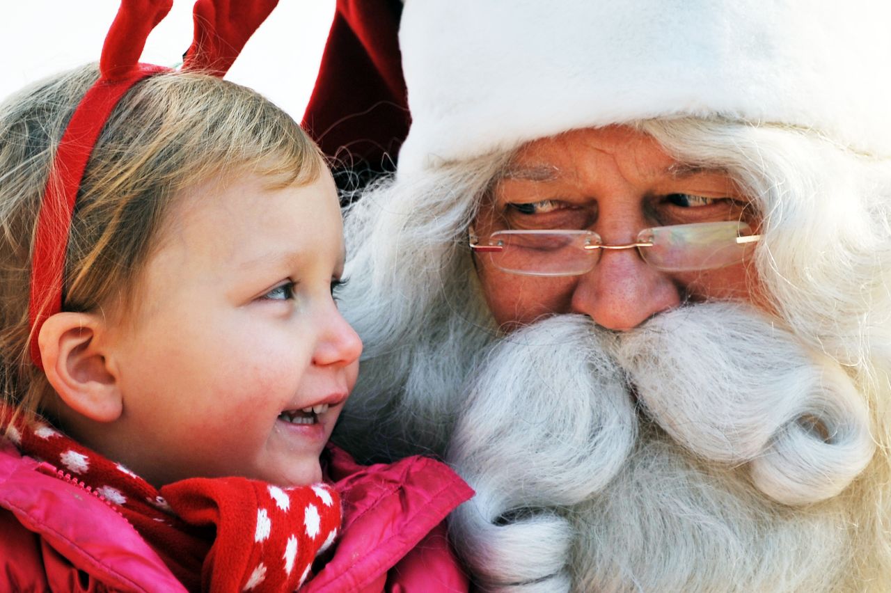 A man dressed as Santa Claus from Lapland, Finland, listens to a girl's Christmas wish on stage at a Christmas event organized by the Finnish Embassy in Seoul, South Korea, on Monday, December 23.