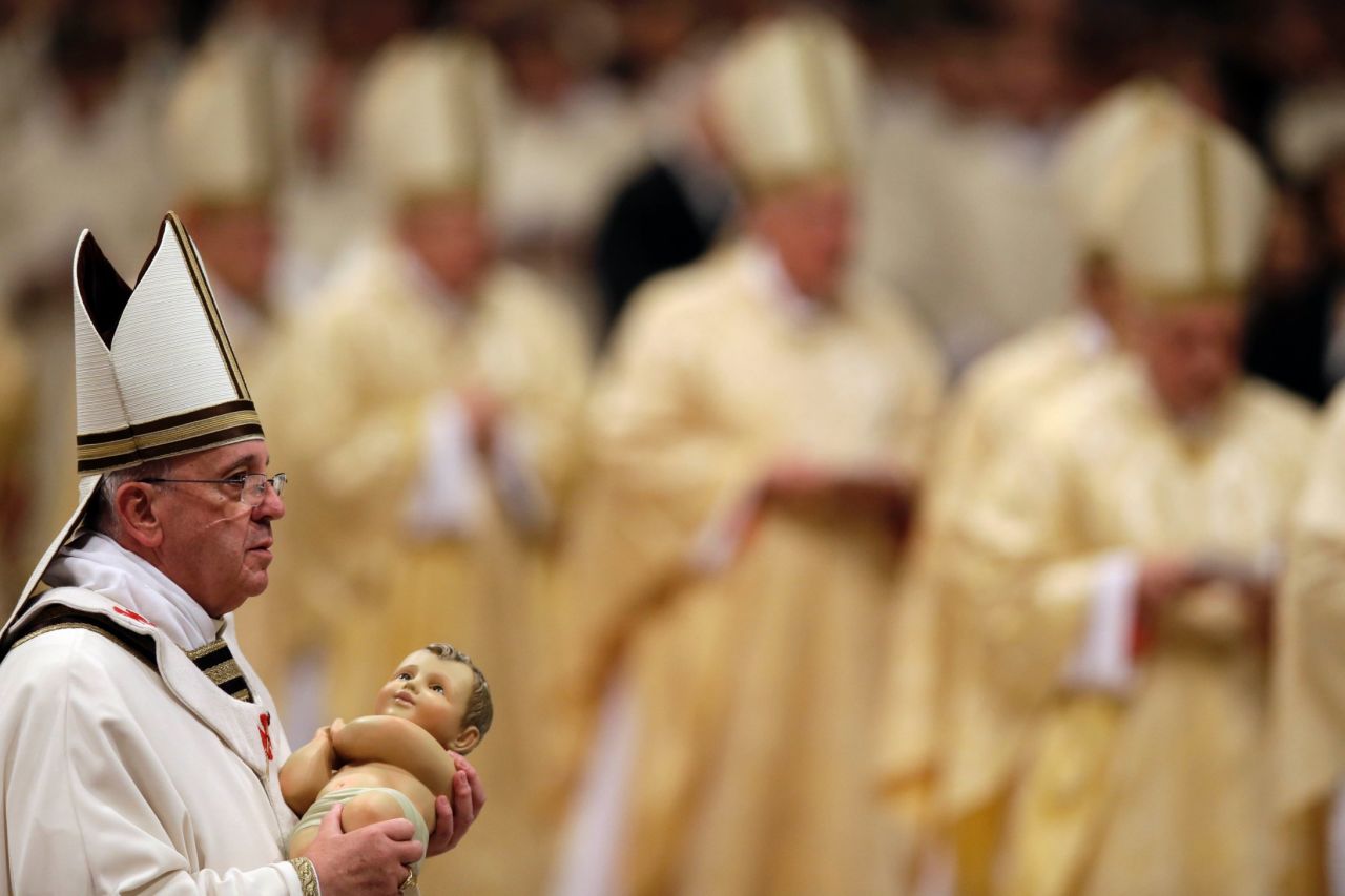 The Pope carries a statue of baby Jesus during the celebrations. On Christmas Day, tens of thousands of pilgrims are expected to flood St. Peter's Square to hear his message to the world.