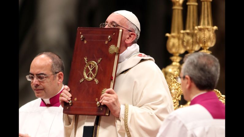 The Pope kisses the book of the Gospels. "God is light and in him there is no darkness at all," the Pope said.
