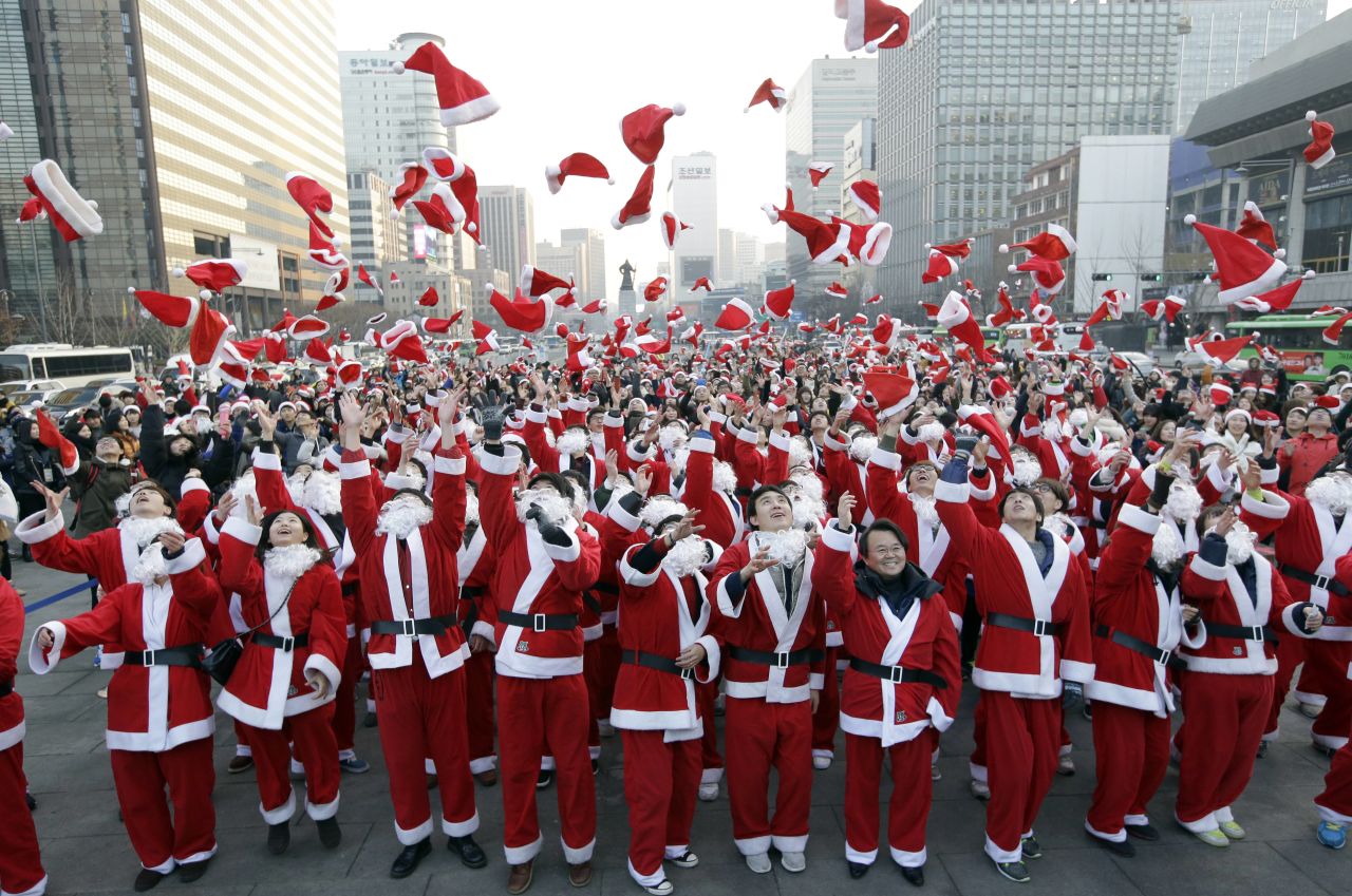 More than 1,000 volunteers clad in Santa Claus costumes throw their hats in the air as they gather to deliver gifts for the poor in downtown Seoul, South Korea, on December 24.