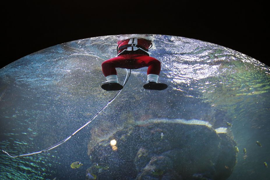 A diver dressed as Santa Claus surfaces after swimming in the Coral Garden tank at the South East Asia Aquarium of Resorts World Sentosa, a popular tourist attraction in Singapore, on December 24.