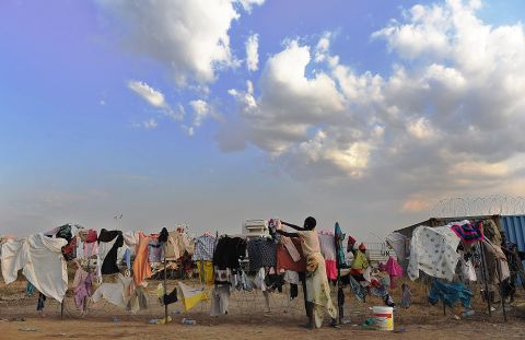 A South Sudanese girl puts her family's laundry out to dry on a barbed-wire fence at a makeshift U.N. camp in Juba on December 22.