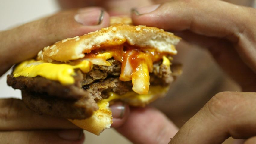 MIAMI BEACH, FL - JULY 18:  Jeff Baughman bites into his Double Quarterpounder with cheese on July 18, 2002 at a McDonalds in Miami Beach, Florida.  The health effects of an American diet of super-sized fast foods are becoming apparent as increasing numbers of children and adults are being treated for obesity.  Studies seem to point to the fact that many overweight children and adults get a large portion of their calories by consuming too many sodas and sweetened juices and beverages.  Sweetened drinks + "super-sized" meals + the convenience of fast food + a decrease in physical activity = a recipe for obesity.  (Photo by Joe Raedle/Getty Images)