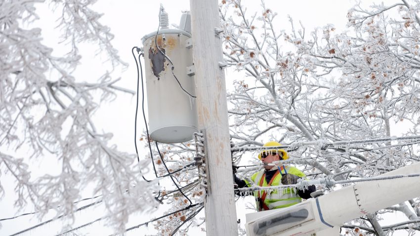 Dave Dora, a lineman from Grand Haven Board of Light and Power, works on connecting fallen wires on Macon Avenue in Lansing, Mich., Monday, Dec. 23, 2013. From Michigan to Maine, hundreds of thousands remain without power days after a massive ice storm _ which one utility called the largest Christmas-week storm in its history _ blacked out homes and businesses in the Great Lakes and Northeast. (AP Photo/Lansing State Journal, Greg DeRuiter)