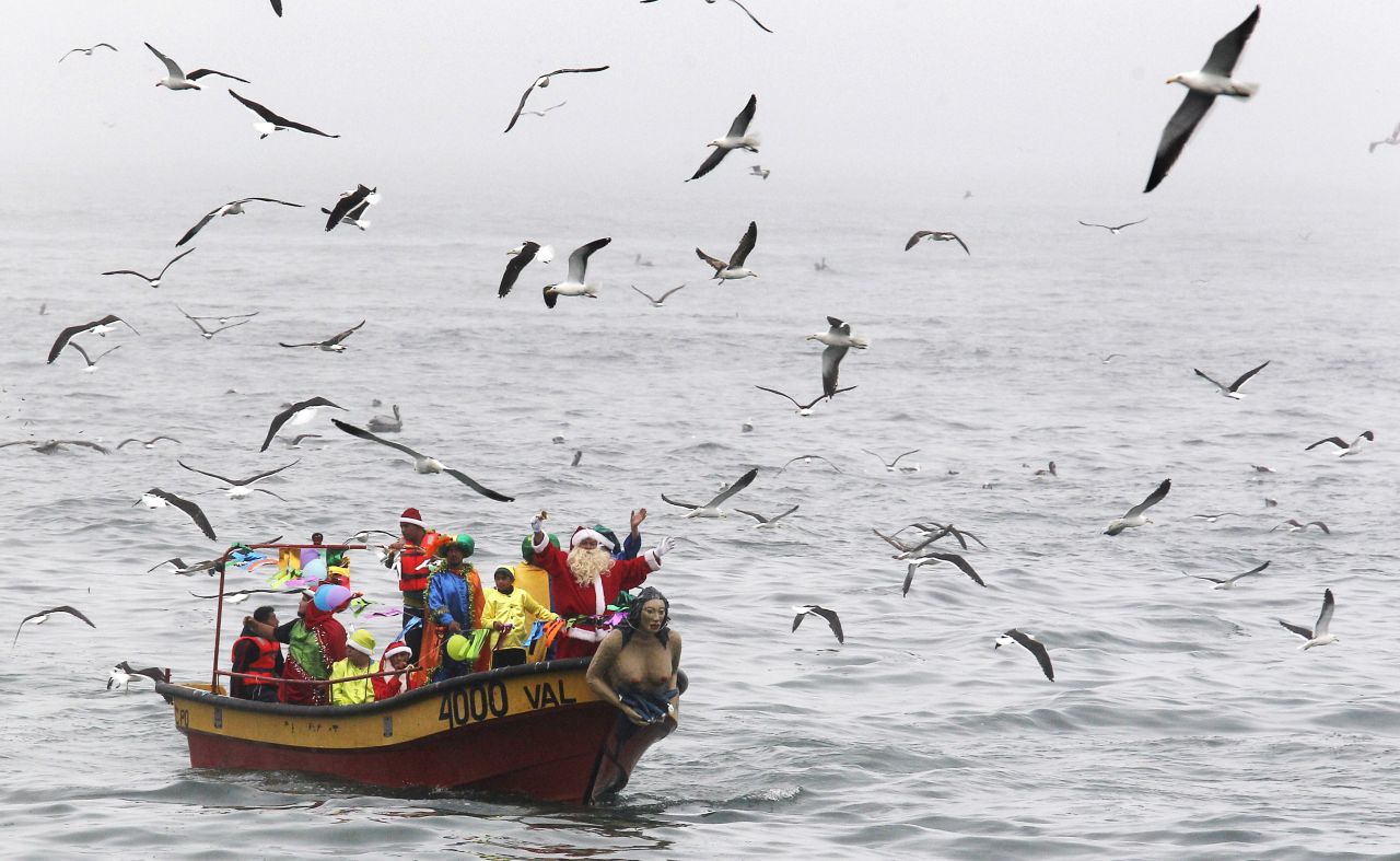 Ruben Torres, dressed in a Santa Claus outfit, waves to people from a boat with fishermen along the coast of Valparaiso, Chile, on December 24. Every year, fishermen in Valparaiso organize a Santa Claus boat trip as people wait on the shore to receive their Christmas presents and well-wishes.
