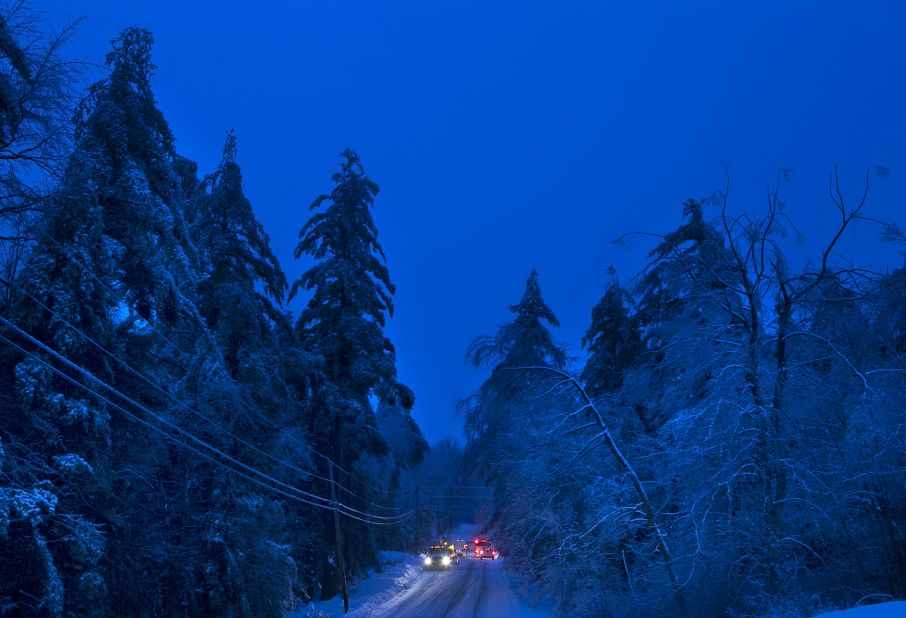 Utility crews prepare to work on power lines at dusk in Litchfield, Maine, on Thursday, December 26. Many have been without electricity since Monday's ice storm, up to 7 inches of snow is forecast, worrying utilities that the additional weight on branches and transmission lines could cause setbacks in the around-the-clock efforts to restore power.