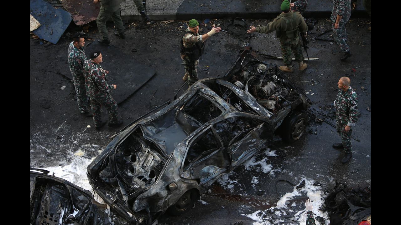 Lebanese soldiers gather around a burned vehicle. Six people were killed in the car bombing and 71 were wounded, Lebanon's health ministry said. Mohamad Chatah, a former Lebanese finance minister and ambassador to the United States, was one of the casualties. 