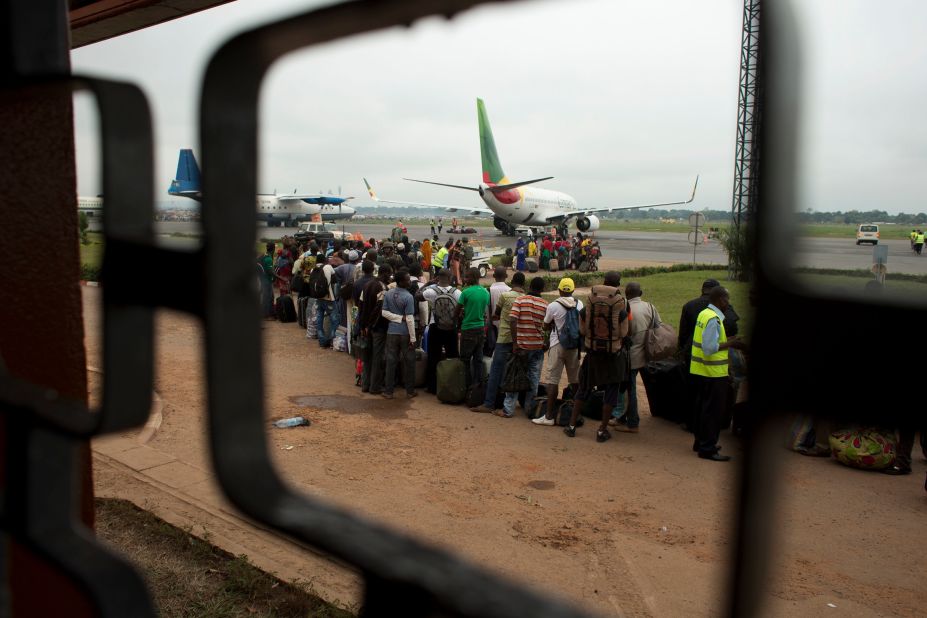Cameroonians wait in line to board an evacuation flight at M'Poko International Airport, which is guarded by French soldiers on December 27. Military escorts shuttled citizens of Chad and Cameroon to the airport Friday to board evacuation flights as French troops stepped in to help Muslims fleeing north by road.