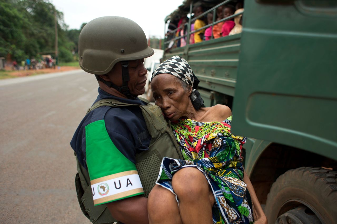 An African Union peacekeeper carries an elderly Cameroonian woman to a military vehicle in Bangui on December 27. 