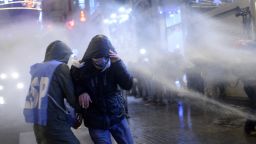 People run away from a water cannon on the Istiklal Avenue on December 27, 2013, during clashes between the Turkish police and protestors. Police blocked hundreds of protesters from gathering in Istanbul's central Taksim Square and pushed them away to the nearby streets. A high-level bribery and corruption investigation involving close government allies has led to a new outpouring of anger against Prime Minister Recep Tayyip Erdogan's government. AFP PHOTO/ BULENT KILICBULENT KILIC/AFP/Getty Images
