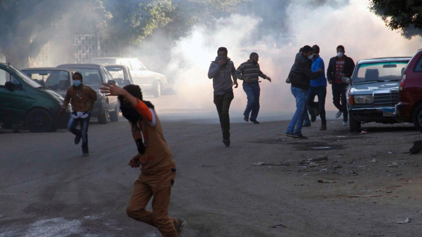 This file photo shows Muslim brotherhood supporters running for cover during clashes with police on the outskirts of Cairo on December 27, 2013.