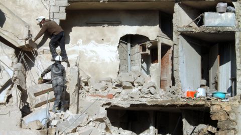 Rescues climb on the rubble of a destroyed building following an airstrike in  Aleppo on December 24.