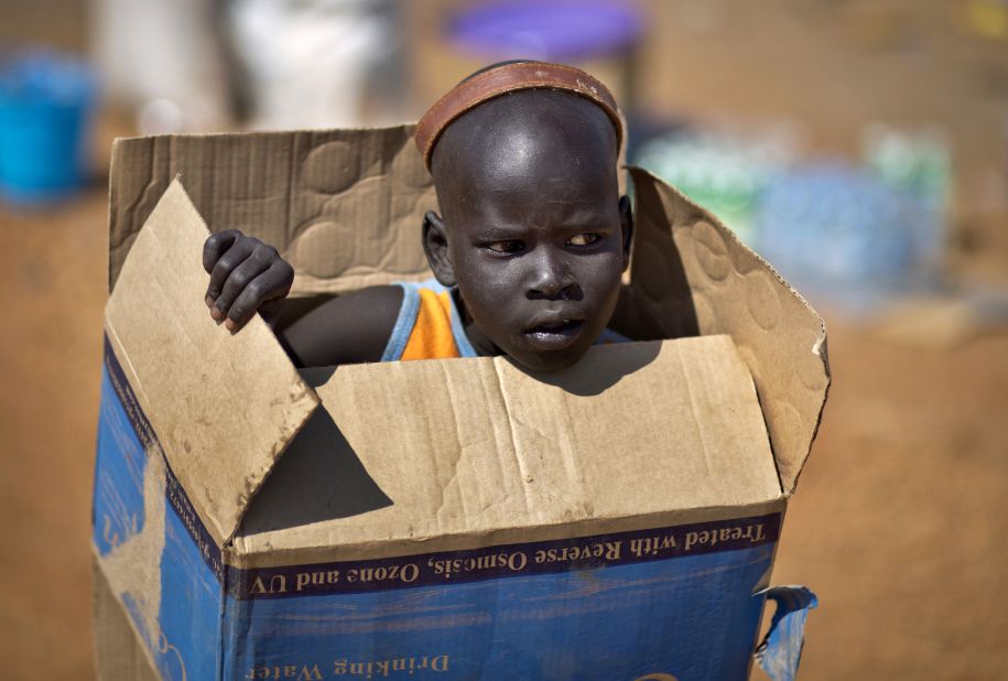 <strong>December 27: </strong>A boy carries a cardboard box in Juba, South Sudan, inside a United Nations compound that has become home to thousands of people displaced by recent fighting in the fledgling African nation.