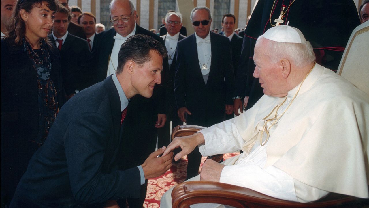 As a growing global celebrity, the German's fame took him away from the race track. Here he meets Pope John Paul II in 1999.