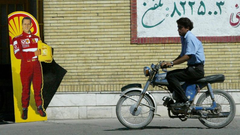 Un hombre pasa junto a un cartel con la imagen de Schumacher en Bahreman, Irán, en 2005.