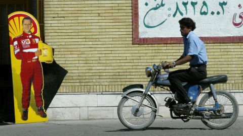 A man rides past a poster with Schumacher's likeness in Bahreman, Iran, in 2005.