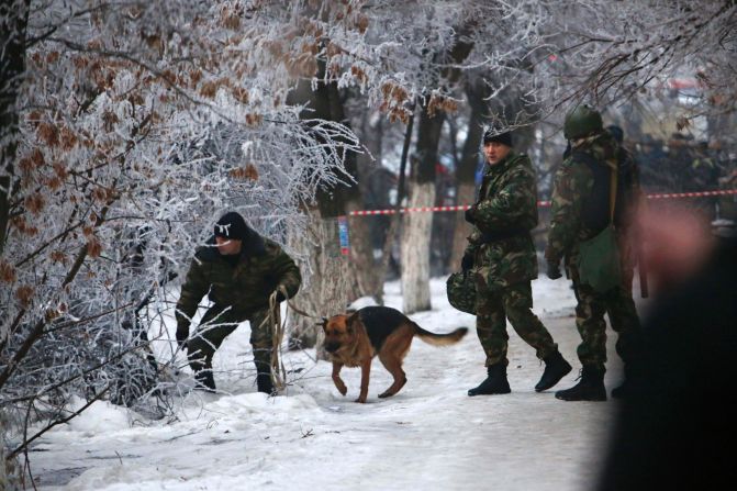 Police officers examine the area around the site of the explosion.