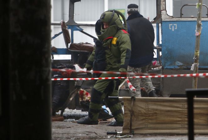 A demolition expert walks among the wreckage.