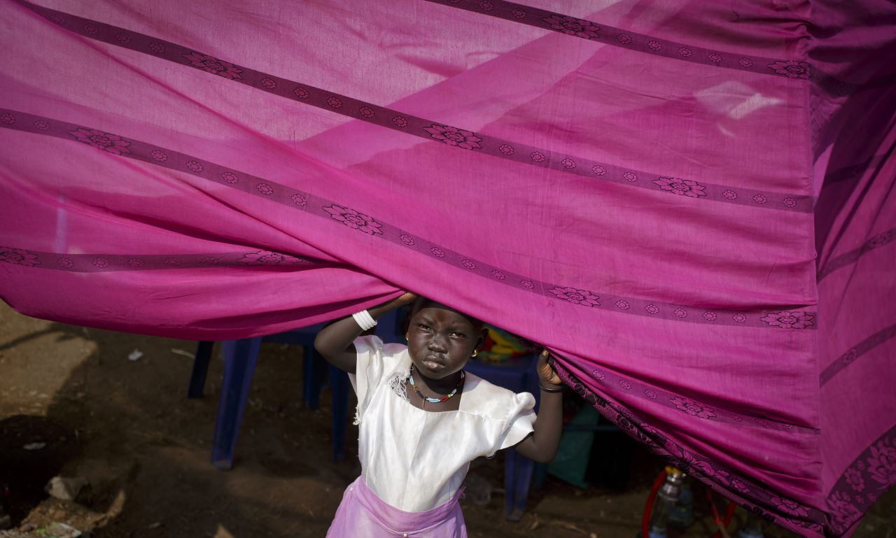 DECEMBER 30 - JUBA, SOUTH SUDAN: A young girl peers from her makeshift tent at a United Nations compound which has become home to thousands of people displaced by the recent fighting. As the humanitarian crisis worsens, the U.N. said Friday the <a href="https://www.cnn.com/2013/12/31/world/gallery/defining-moments-archive-12-2013/cnn.com/2013/12/29/world/africa/south-sudan-conflict/index.html">first of 5,500 additional peacekeepers had arrived in the country.</a>