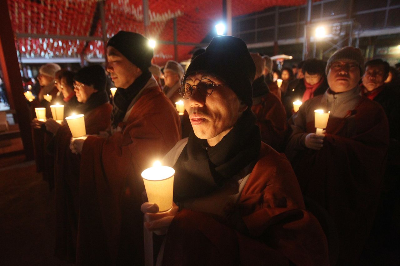 Buddhist monks hold candles during celebrations at a temple in Seoul, South Korea.