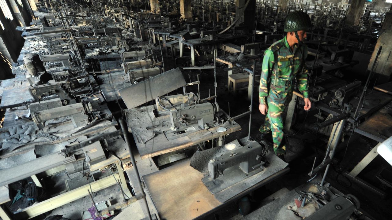 A Bangladeshi Army personel walks through rows of burnt sewing machines after a fire in the plant.