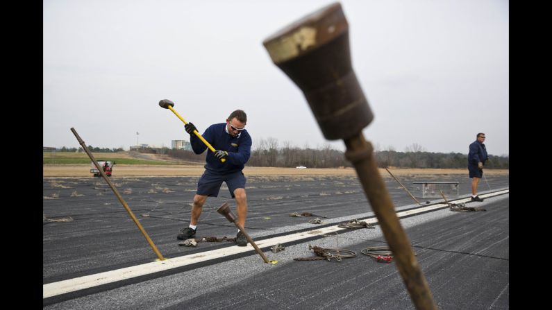 Scott Suter, an airframe and power plant mechanic, uses a sledgehammer to secure support posts into the runway. Suter is one of the ground crew members for Spirit of Innovation, which is based in Pompano Beach, Florida.
