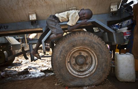 A boy rests on the fender of a water truck Tuesday, December 31, at a United Nations compound on the outskirts of Juba, South Sudan. The compound has become home to thousands fleeing the recent fighting in South Sudan. 